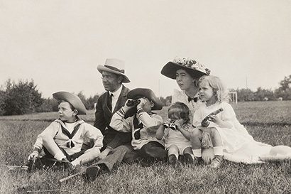 Gustaf VI Adolf och kronprinsessan Margareta sitter i gräset tillsammans med barnen prins Sigvard, prins Gustaf Adolf, prins Bertil och prinsessan Ingrid